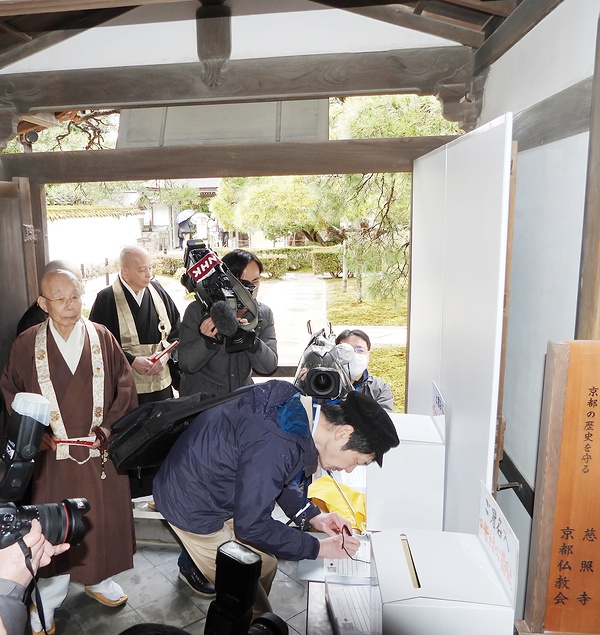 京都仏教会の呼び掛けで署名活動に応じる銀閣寺の拝観者