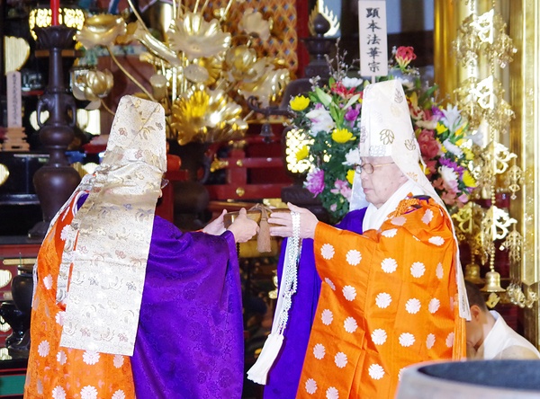 大川前管長が奥村新管長㊨に日什大正師御染筆の「諷誦章」を親授した