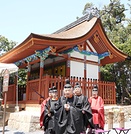 失われていた彩色を復元し修理された石清水八幡宮の狩尾神社と田中恆清宮司。14本の柱のうち10本が古材と判明した
