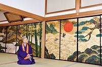 弘法大師に見立てた太陽が象徴的に描かれた四季山水花鳥図を眺める宮田住職