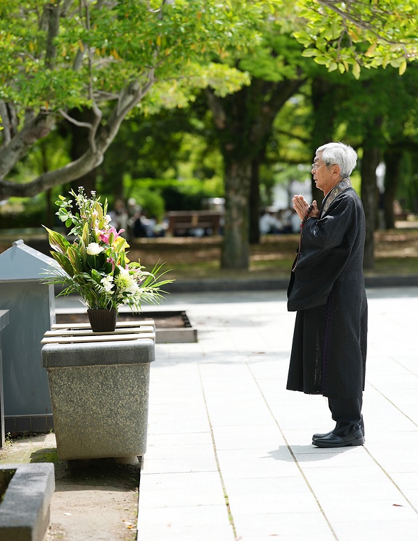 平和記念公園で合掌する真宗大谷派の大谷暢裕門首＝真宗大谷派山陽教務所提供