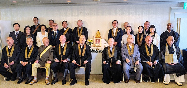 山田前会長の遺影を囲む出席者。平井新会長は前列右から4人目