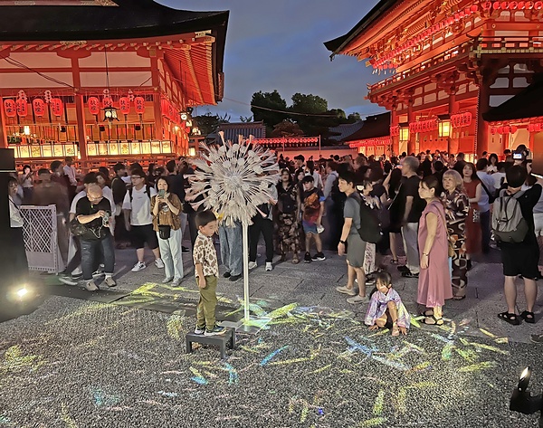 境内の地面に映し出されたタンポポの映像を楽しむ子どもたち