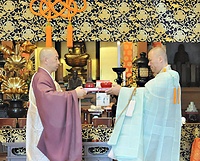 鉄舟居士の尊前にあんパンを奠供する平井住職㊧
