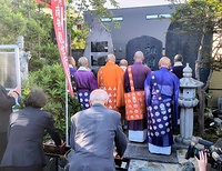 慰霊碑前で祈りを捧げる僧侶ら