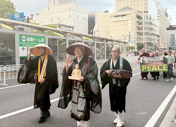 広島市内を歩く中垣氏(左)と前田氏(中央)=前田氏提供