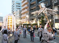 威勢よく纏を振って進む万灯練り行列