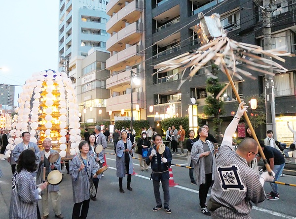 威勢よく纏を振って進む万灯練り行列