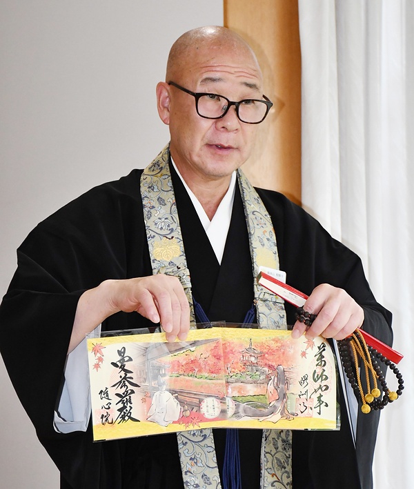 初のコラボ御朱印を紹介する醍醐寺の大原弘敬執行長（右が醍醐寺、左が隨心院の御朱印）