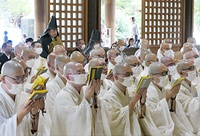 感染対策でマスクを着け読経する入行僧（法華経寺行堂）