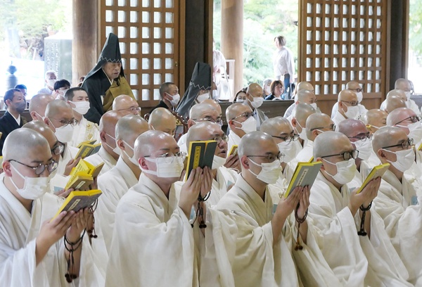 感染対策でマスクを着け読経する入行僧（法華経寺行堂）