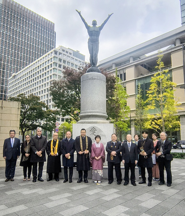 東京駅丸の内駅前広場に立つ「愛の像」前で記念撮影に臨むメンバーら
