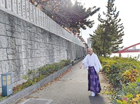 幅5㍍の遊歩道(高潮堤防)上に建設される橋脚の位置を指さし、歩行者の安全が確保されなくなることを危惧する森脇宮司