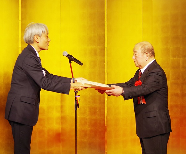 表彰を受ける里雄氏（右）