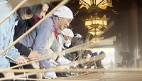 本山真宗本廟の御影堂で、竹の棒を使って畳をたたき1年間のほこりを払う門徒ら