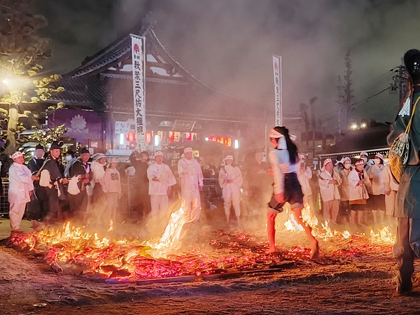 火まつり・火渡り神事で火の中を進む参加者