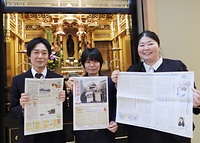 新しい紙面を掲げる編集スタッフ