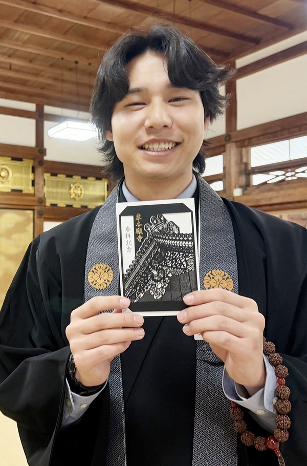 参拝証を手に「行列ができそうなくらいお求めの方が来られる」と話す参拝接待所の職員