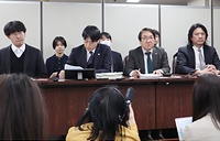 閉廷後に東京都内で会見する男性（左端）と弁護士ら