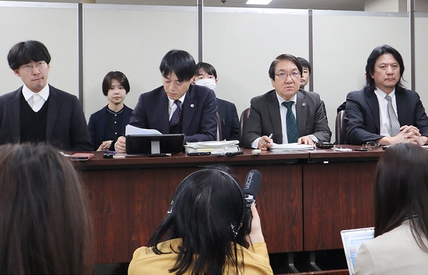閉廷後に東京都内で会見する男性（左端）と弁護士ら