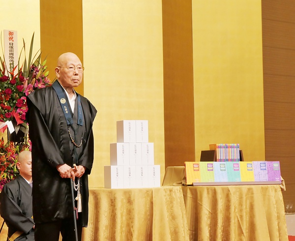 祖願達成へ国際布教の重要性を説く持田日勇・総本山身延山久遠寺法主。隣は発刊した書籍