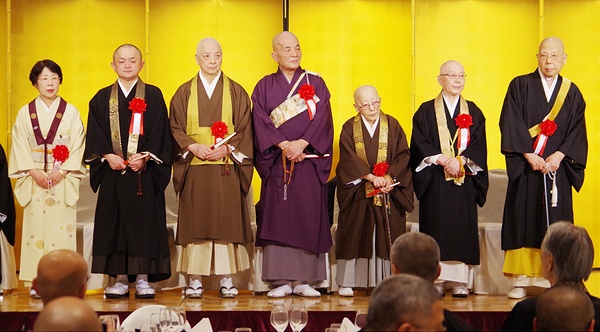 壇上に並ぶ次期会長・副会長。右から持田会長、副会長の武田圓寵・天台真盛宗管長、沢田教英・西山浄土宗管長、松村隆誉・真言律宗管長、小澤憲珠・東京都仏教連合会会長、山下俊茂・福岡県仏教連合会事務局長、東伏見具子・全日本仏教婦人連盟会長