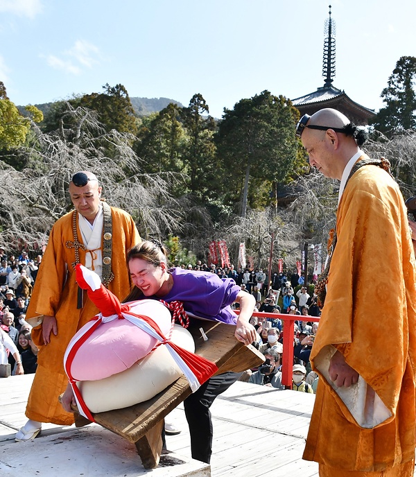 90㌔の鏡餅を必死の形相で持ち上げようとする参加者