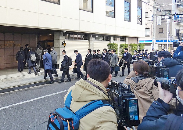 報道陣が取り囲む教団本部に入る清算手続きの関係者ら