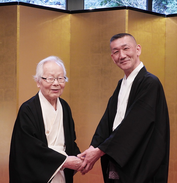 笑顔で握手を交わす友田新宮司（右）と新木前宮司（3日）
