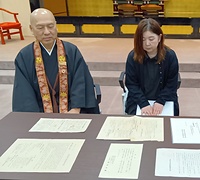 戦時資料を見る川原氏㊨と寄贈を受けた藤本局長