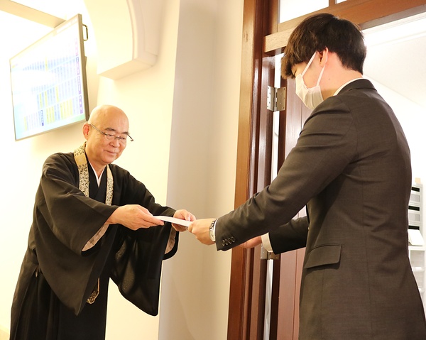 京都市会に請願書を提出する京都仏教会の長澤香静・事務局長㊧