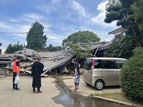 八代市の被災寺院を訪問する真宗大谷派災害救援本部長の轡田参務ら＝同派提供