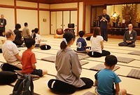 僧侶の指導で坐禅を体験する参加者
