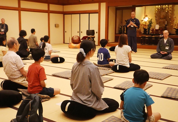 僧侶の指導で坐禅を体験する参加者