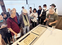 23日の野村朋弘氏(右端)の展示解説には大勢の拝観者が集まった