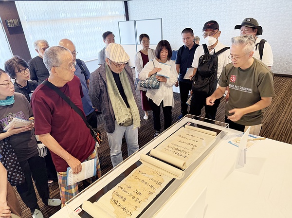 23日の野村朋弘氏（右端）の展示解説には大勢の拝観者が集まった