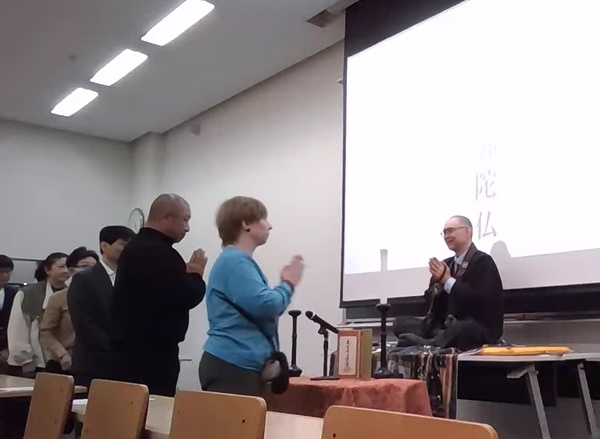 谷山教授と合掌礼を交わす生前葬の参加者