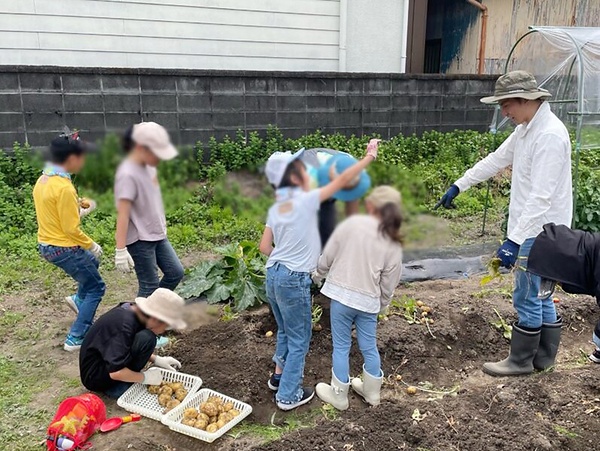 地域の子どもたちと行った今年の春のジャガイモの収穫。右端が髙瀬副住職(写真は一部加工しています)