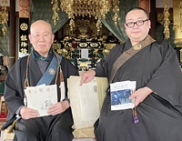 寺報『サットバ』を手にする川口正継住職㊨と日空前住職