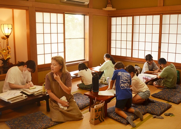 学校の宿題に真剣に取り組む子どもら