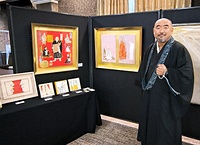 8月に築地本願寺で催した作品展に出展した自身の作品の前で