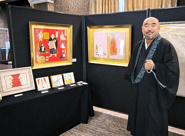 8月に築地本願寺で催した作品展に出展した自身の作品の前で