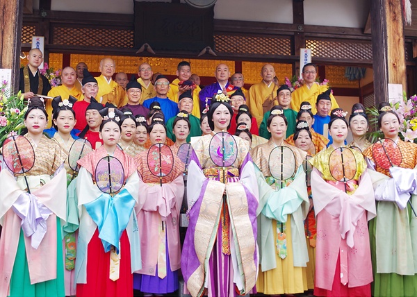 東塔基壇の石を手にした坂東住職（最後列中央）と参列者ら