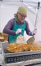 輪島市の温泉施設で開いた炊き出しで焼きそばを焼く石﨑住職（2025年11月）