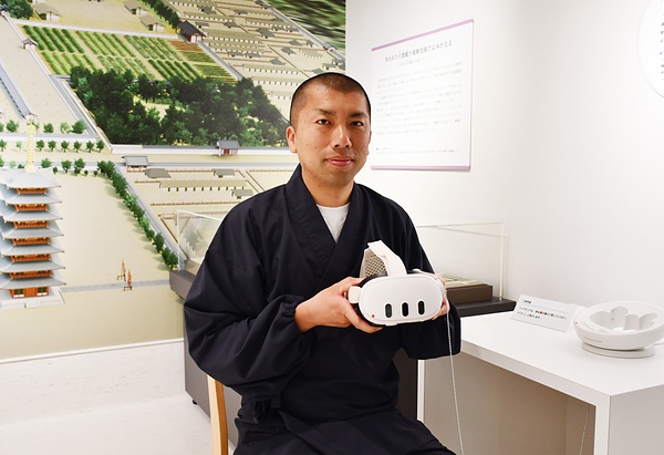 復元伽藍をVR体験できるゴーグル型機器を手にする河野副住職
