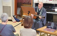 ピアノの生伴奏で歌謡曲を楽しむ集いでギターを手に熱唱する平田住職