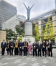 東京駅丸の内駅前広場に立つ「愛の像」前で記念撮影に臨むメンバーら